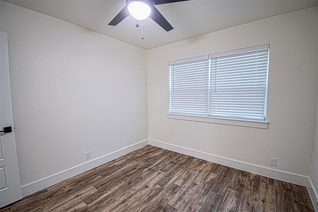 551 East Burks Street Pilot Point, TX 76258 - Photo 27 of 29 a view of an empty room with wooden floor and a window