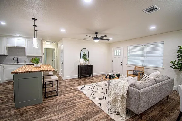 a living room with furniture and a wooden floor