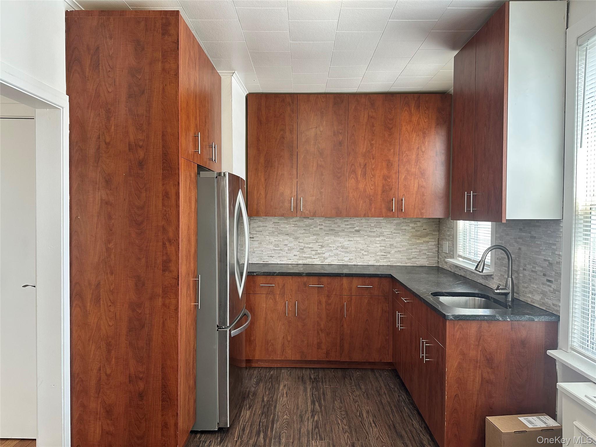 a kitchen with a sink a refrigerator and cabinets