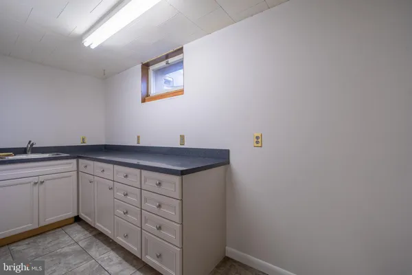 a view of cabinets a sink wooden floor and a window in a room