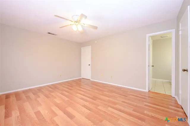 a view of an empty room with a chandelier fan