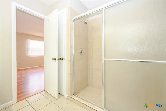 a bathroom with a shower and a glass door