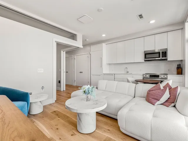 a living room with stainless steel appliances kitchen island furniture and a view of kitchen