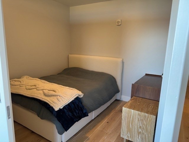 191 Washington Street, Unit 507 Boston, MA 02135 - Photo 12 of 23 a bedroom with a bed and a chair
