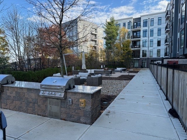 191 Washington Street, Unit 507 Boston, MA 02135 - Photo 19 of 23 a view of a patio with couches and table and chairs next to a yard