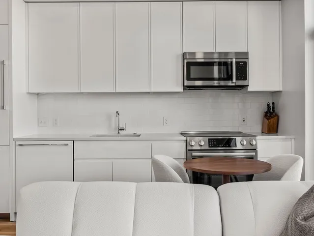 a kitchen with stainless steel appliances a stove a microwave and sink