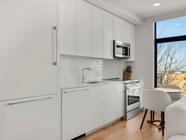 a kitchen with stainless steel appliances white cabinets and a refrigerator