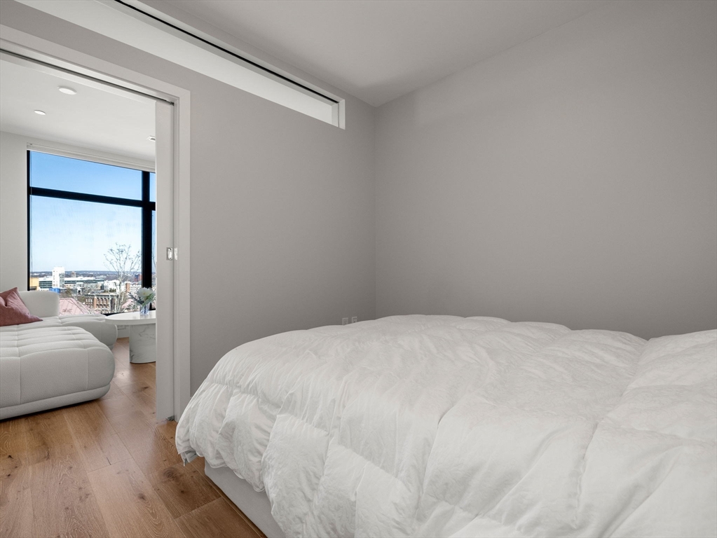 191 Washington Street, Unit 507 Boston, MA 02135 - Photo 5 of 23 a bedroom with a bed and a large window