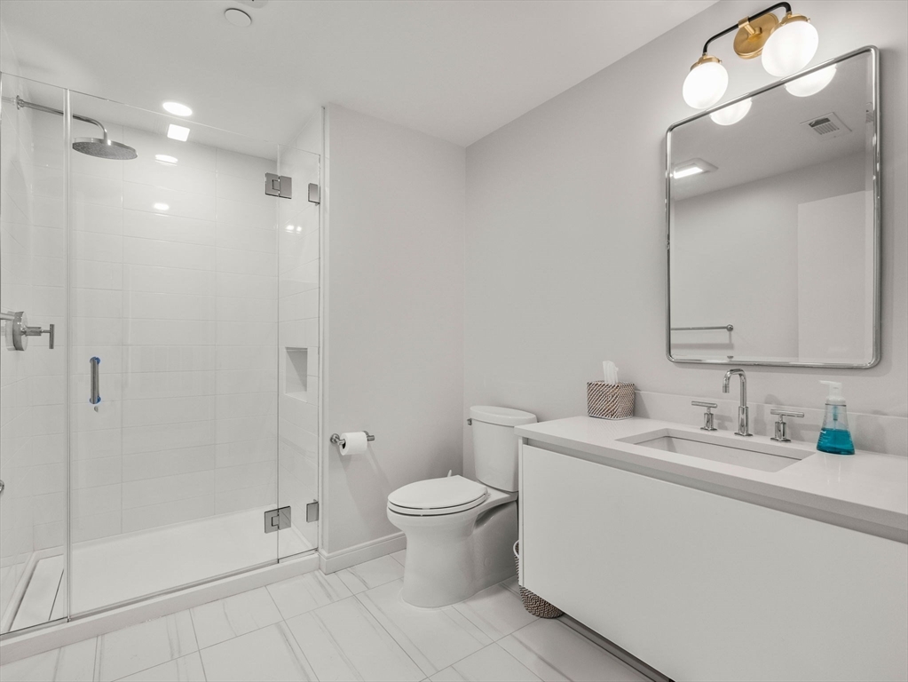 191 Washington Street, Unit 507 Boston, MA 02135 - Photo 6 of 23 a bathroom with a toilet sink and shower