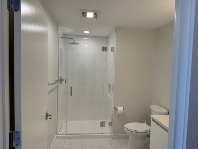191 Washington Street, Unit 507 Boston, MA 02135 - Photo 9 of 23 a bathroom with a granite countertop toilet a sink and shower