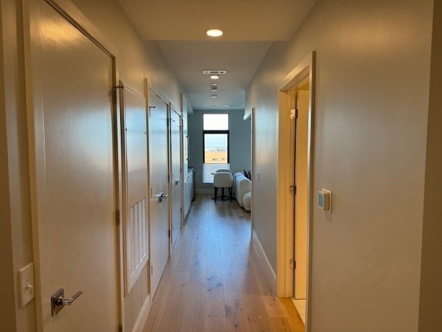191 Washington Street, Unit 507 Boston, MA 02135 - Photo 10 of 23 a view of a hallway with wooden floor and a bathroom