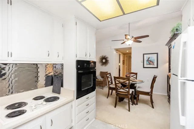 a kitchen with stainless steel appliances kitchen island granite countertop a table chairs in it and wooden floors