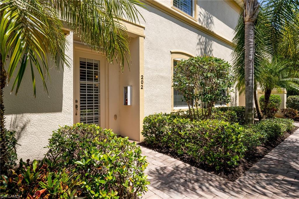 26479 Lucky Stone Road, Unit 202 Bonita Springs, FL 34135 - Photo 11 of 38 a front view of a house with a yard
