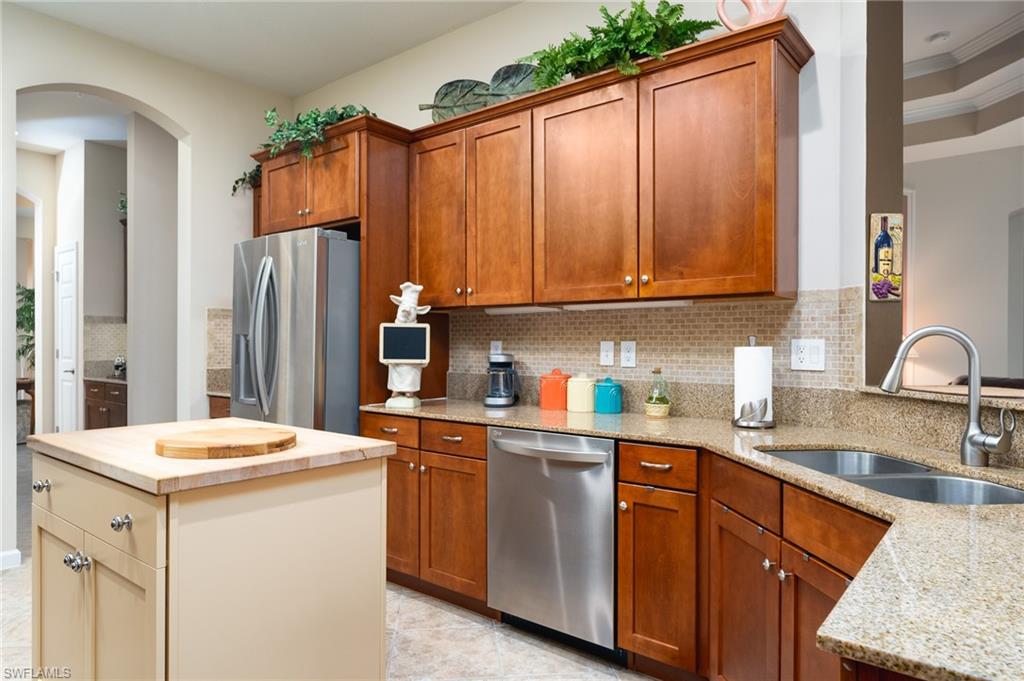 26479 Lucky Stone Road, Unit 202 Bonita Springs, FL 34135 - Photo 16 of 38 a kitchen with stainless steel appliances granite countertop a refrigerator sink and cabinets