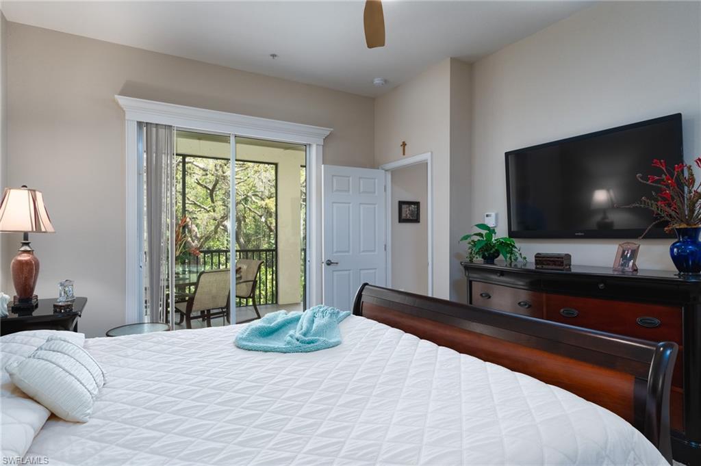 26479 Lucky Stone Road, Unit 202 Bonita Springs, FL 34135 - Photo 23 of 38 a bedroom with a bed and a flat screen tv