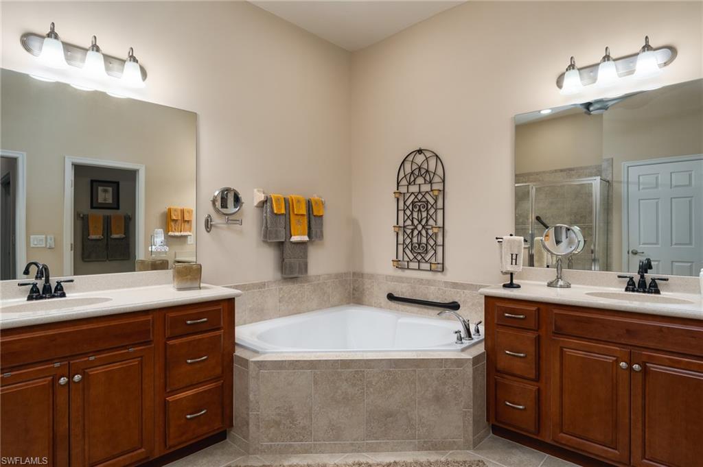 26479 Lucky Stone Road, Unit 202 Bonita Springs, FL 34135 - Photo 24 of 38 a spacious bathroom with a tub double sink and mirror
