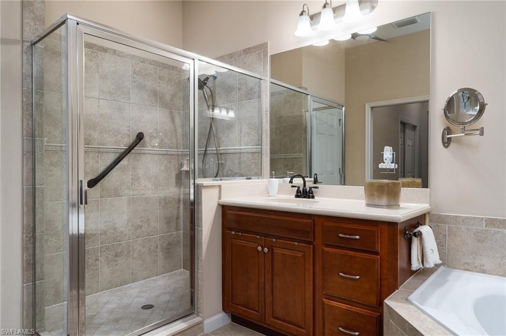 26479 Lucky Stone Road, Unit 202 Bonita Springs, FL 34135 - Photo 25 of 38 a bathroom with a shower sink and mirror