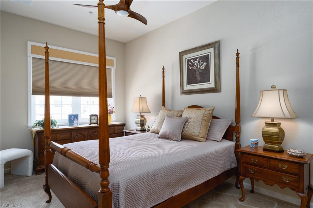 26479 Lucky Stone Road, Unit 202 Bonita Springs, FL 34135 - Photo 26 of 38 a bedroom with a bed and a lamp on table