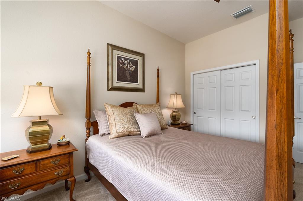 26479 Lucky Stone Road, Unit 202 Bonita Springs, FL 34135 - Photo 27 of 38 a bedroom with a bed and wooden floor