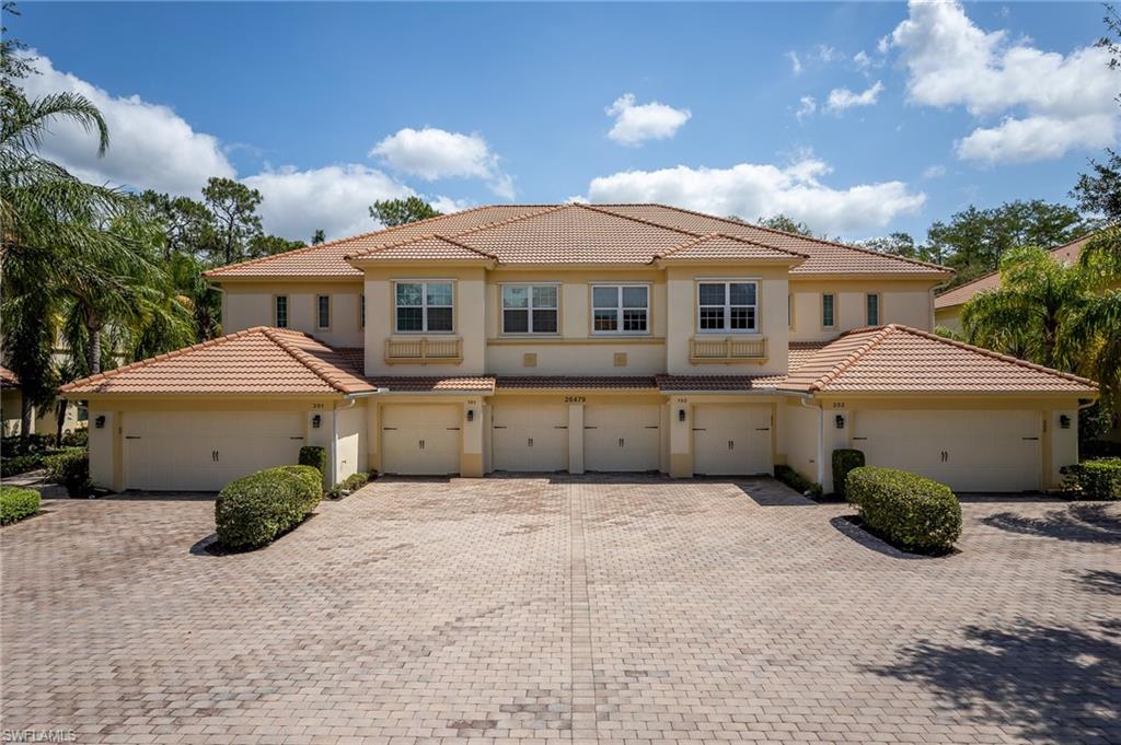 26479 Lucky Stone Road, Unit 202 Bonita Springs, FL 34135 - Photo 3 of 38 a front view of a house with a garden