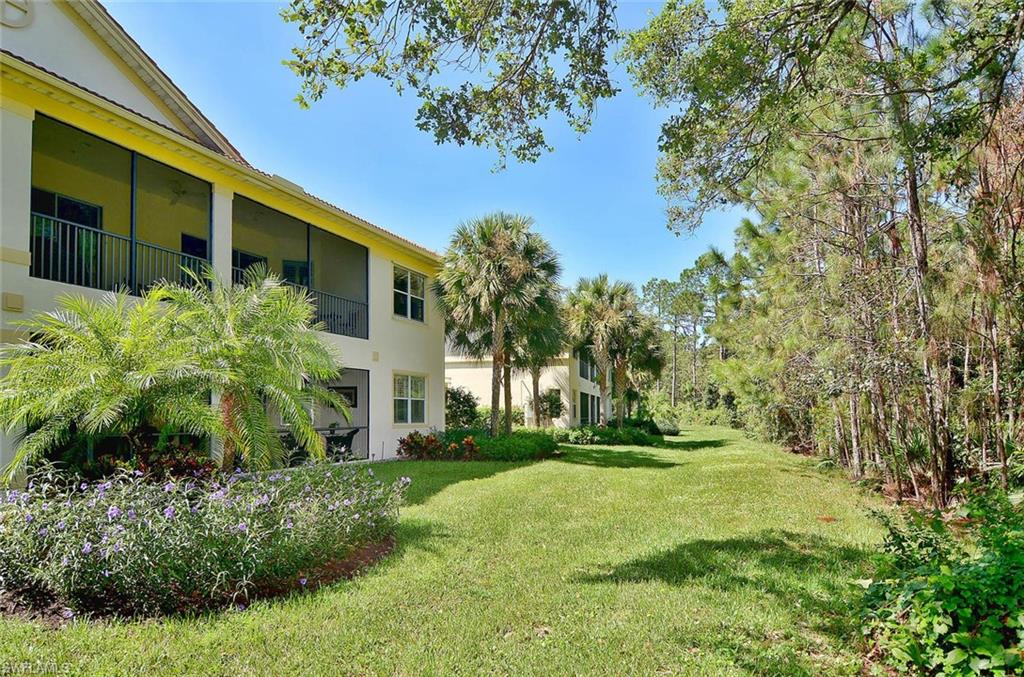26479 Lucky Stone Road, Unit 202 Bonita Springs, FL 34135 - Photo 5 of 38 a front view of a house with a yard