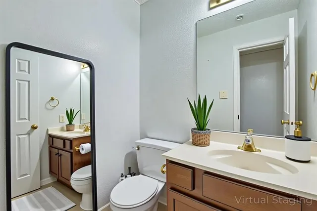 a bathroom with a granite countertop sink a toilet and a mirror