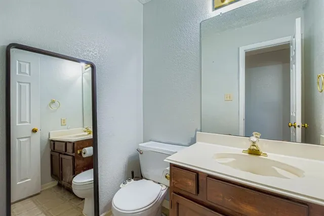 a bathroom with a sink a toilet and mirror