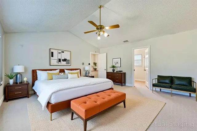 a bedroom with a bed a couch and a chandelier