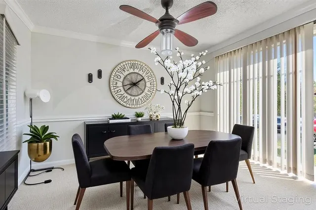 a dining room with furniture a potted plant and a chandelier