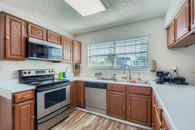 a kitchen with stainless steel appliances a stove sink microwave and cabinets