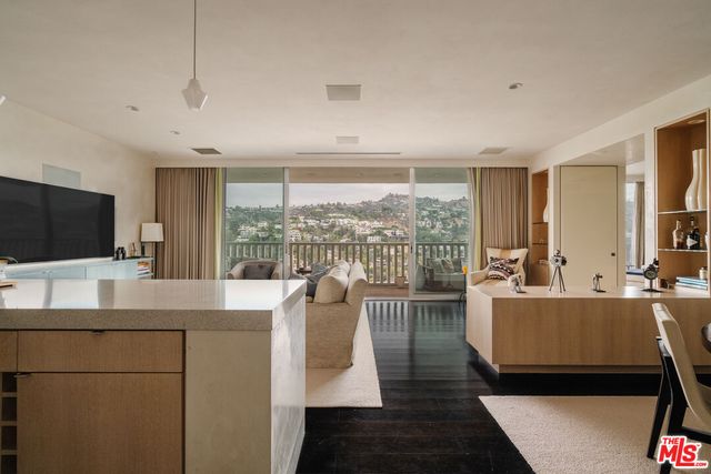 a living room with furniture a flat screen tv and a large window