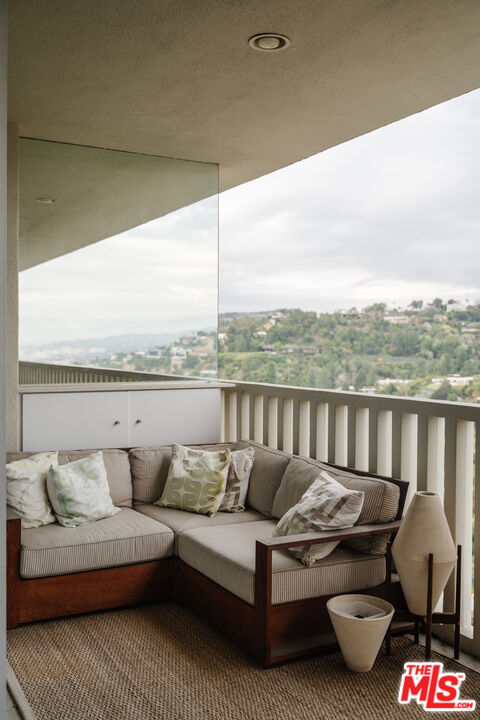 9255 Doheny Road, Unit 2603 West Hollywood, CA 90069 - Photo 26 of 32 a balcony with furniture and a floor to ceiling window
