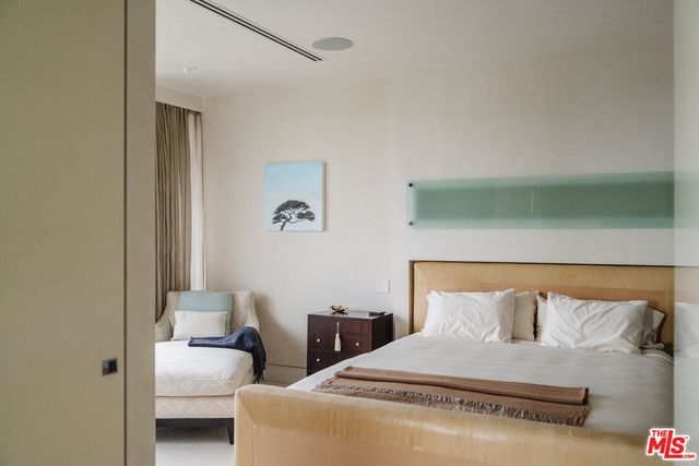 a bedroom with a bed and a potted plant