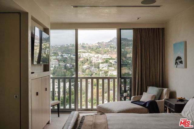 a bedroom with a bed and a large window