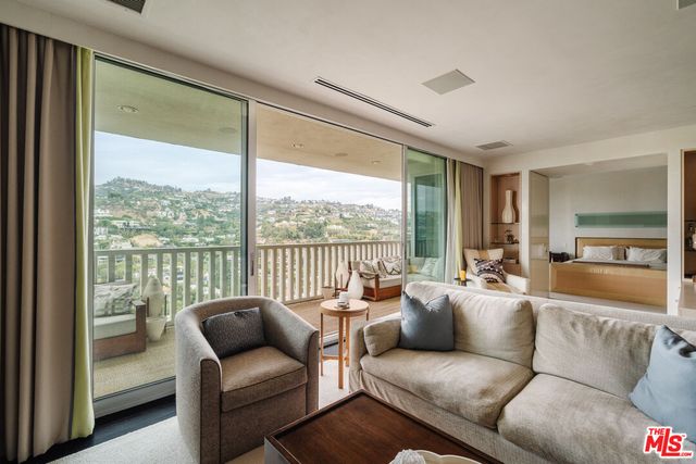 a living room with furniture and a floor to ceiling window