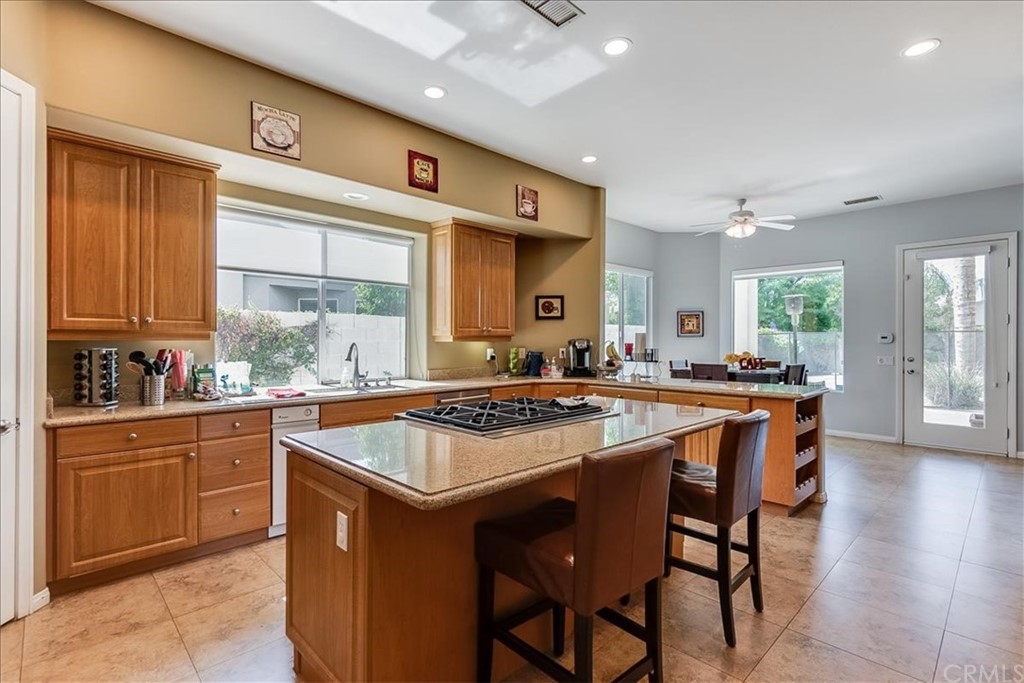 5 Champagne Circle Rancho Mirage, CA 92270 - Photo 14 of 41 a kitchen with a stove a sink a dining table and chairs