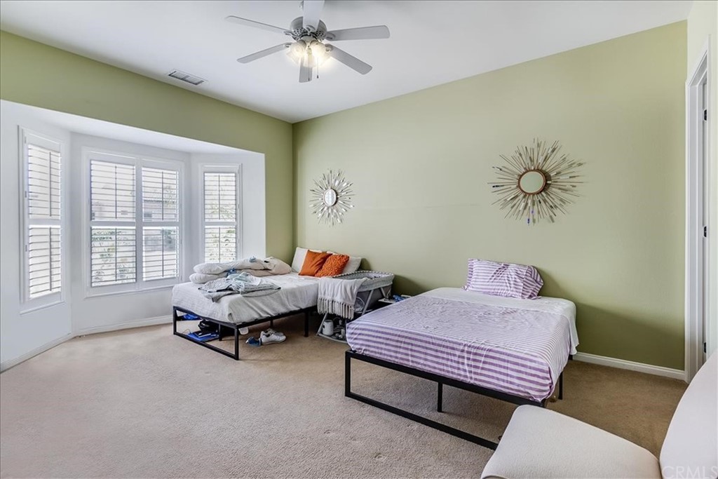 5 Champagne Circle Rancho Mirage, CA 92270 - Photo 26 of 41 a bedroom with two beds and a chandelier