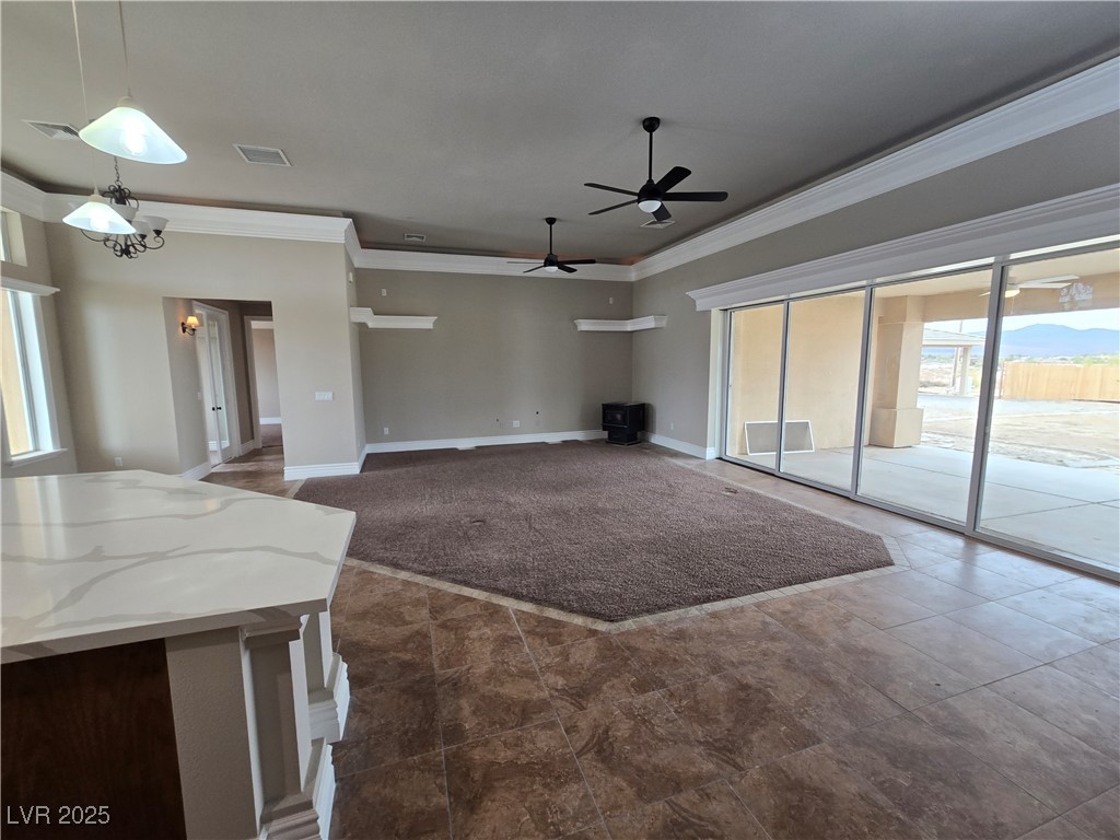 4320 Tiger Road Pahrump, NV 89048 - Photo 7 of 33 Unfurnished living room with plenty of natural light, crown molding, and a ceiling fan