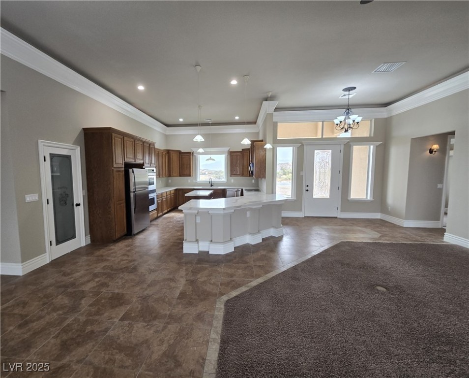 4320 Tiger Road Pahrump, NV 89048 - Photo 33 of 33 Kitchen featuring open floor plan, crown molding, decorative light fixtures, light countertops, and a chandelier