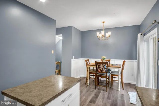 a living room with furniture a fireplace a flat screen tv and kitchen view