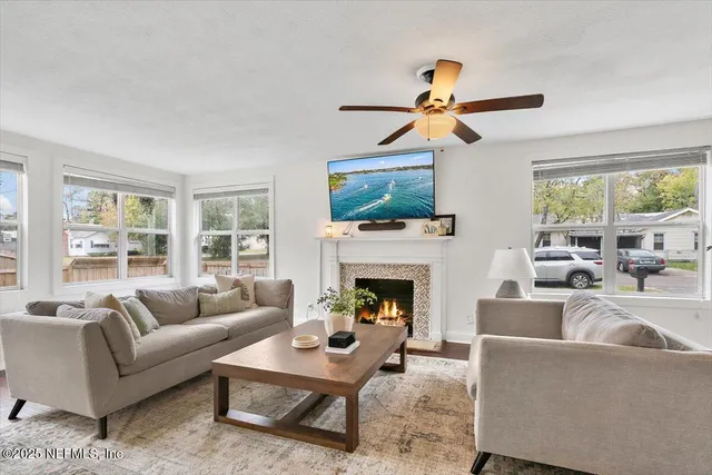 a living room with furniture a fireplace and a flat screen tv