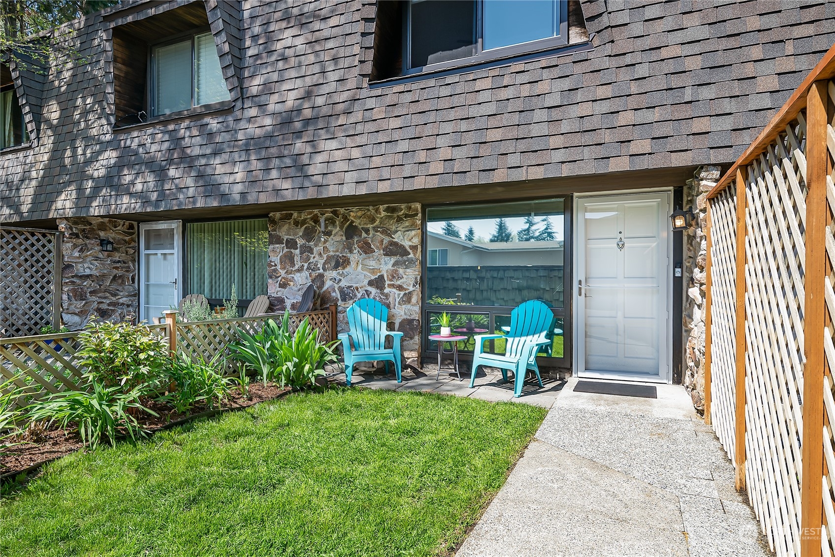 20620 76th Avenue West, Unit D Edmonds, WA 98026 - Photo 1 of 30 a view of a brick house with a large window and potted plants