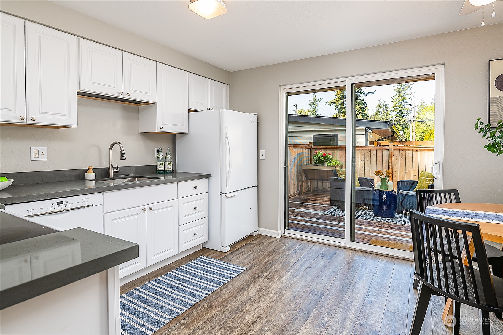 20620 76th Avenue West, Unit D Edmonds, WA 98026 - Photo 8 of 30 a kitchen with stainless steel appliances a refrigerator a stove a sink and white cabinets with wooden floors