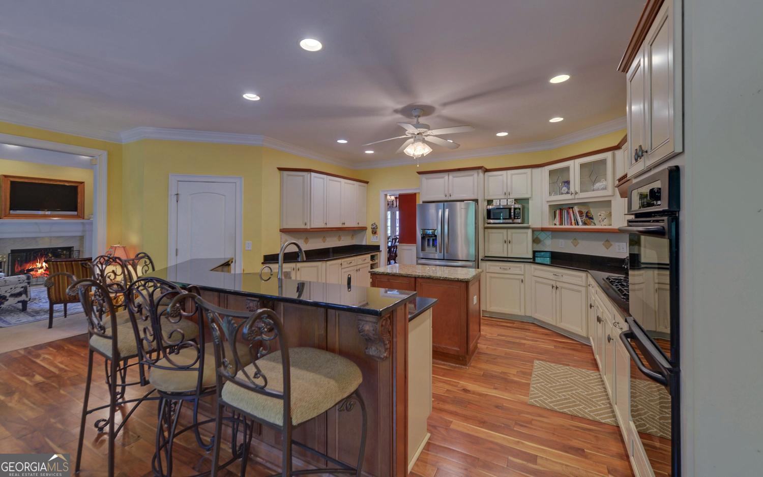 227 Capri Drive Hartwell, GA 30643 - Photo 11 of 75 a kitchen with stainless steel appliances kitchen island granite countertop a refrigerator a stove a sink a dining table and chairs with wooden floor
