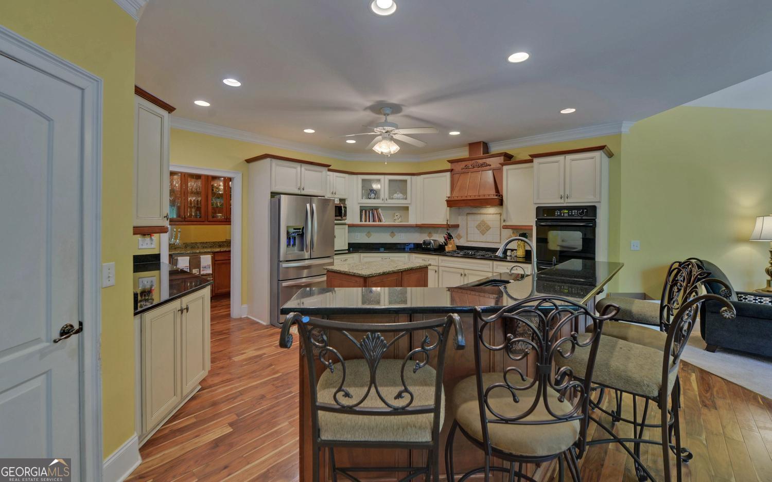 227 Capri Drive Hartwell, GA 30643 - Photo 12 of 75 a kitchen with stainless steel appliances kitchen island granite countertop a table chairs and a refrigerator