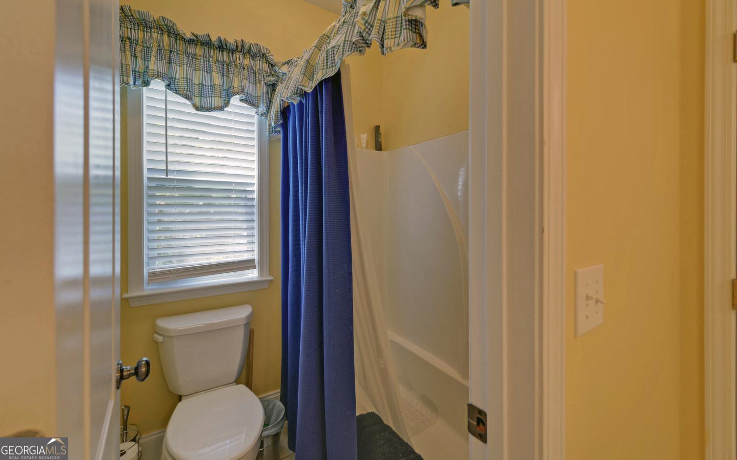 227 Capri Drive Hartwell, GA 30643 - Photo 37 of 75 a bathroom with a toilet and a shower curtain