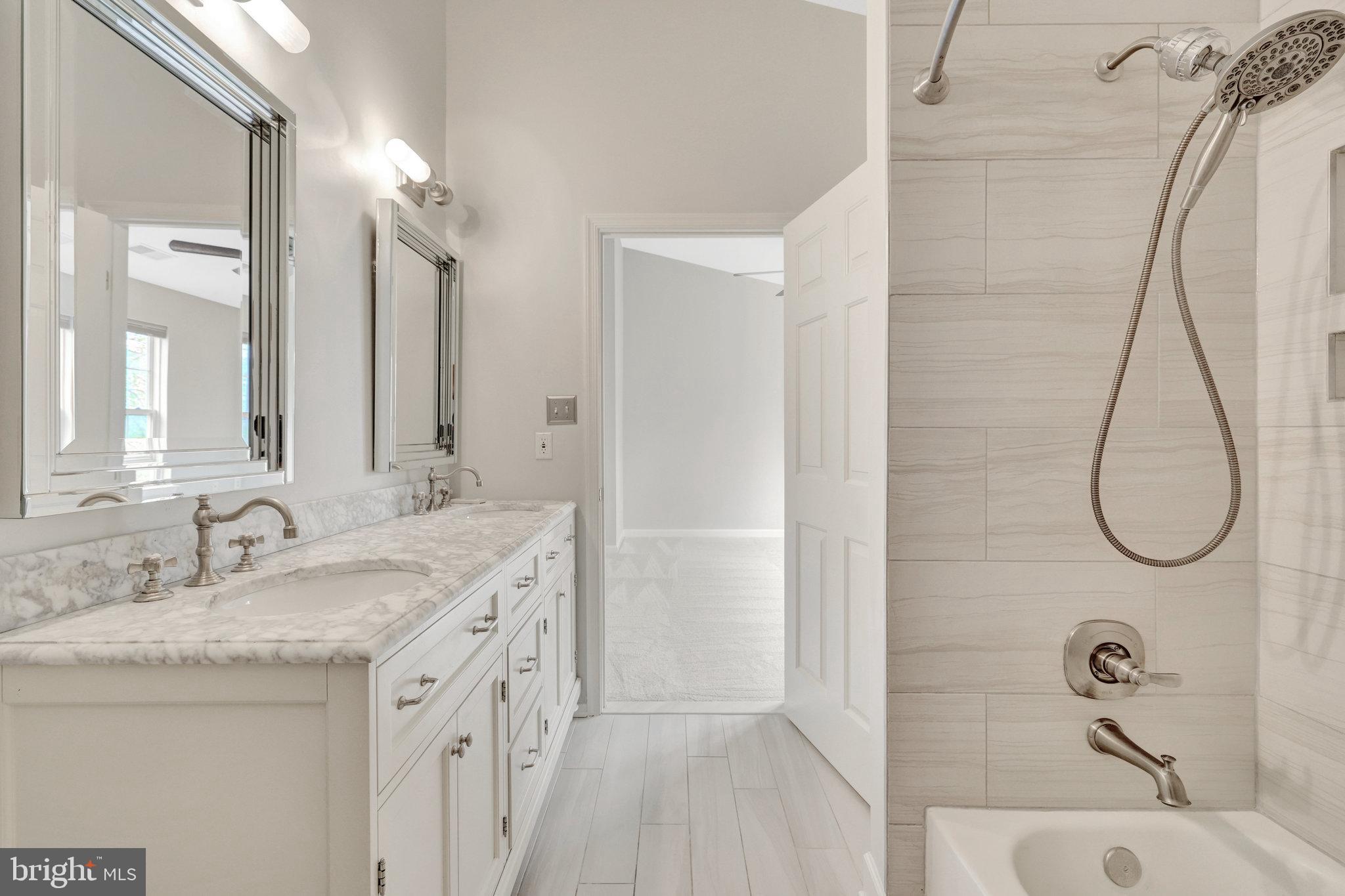 43233 Stillforest Terrace Ashburn, VA 20147 - Photo 15 of 24 a bathroom with a granite countertop sink a mirror and shower