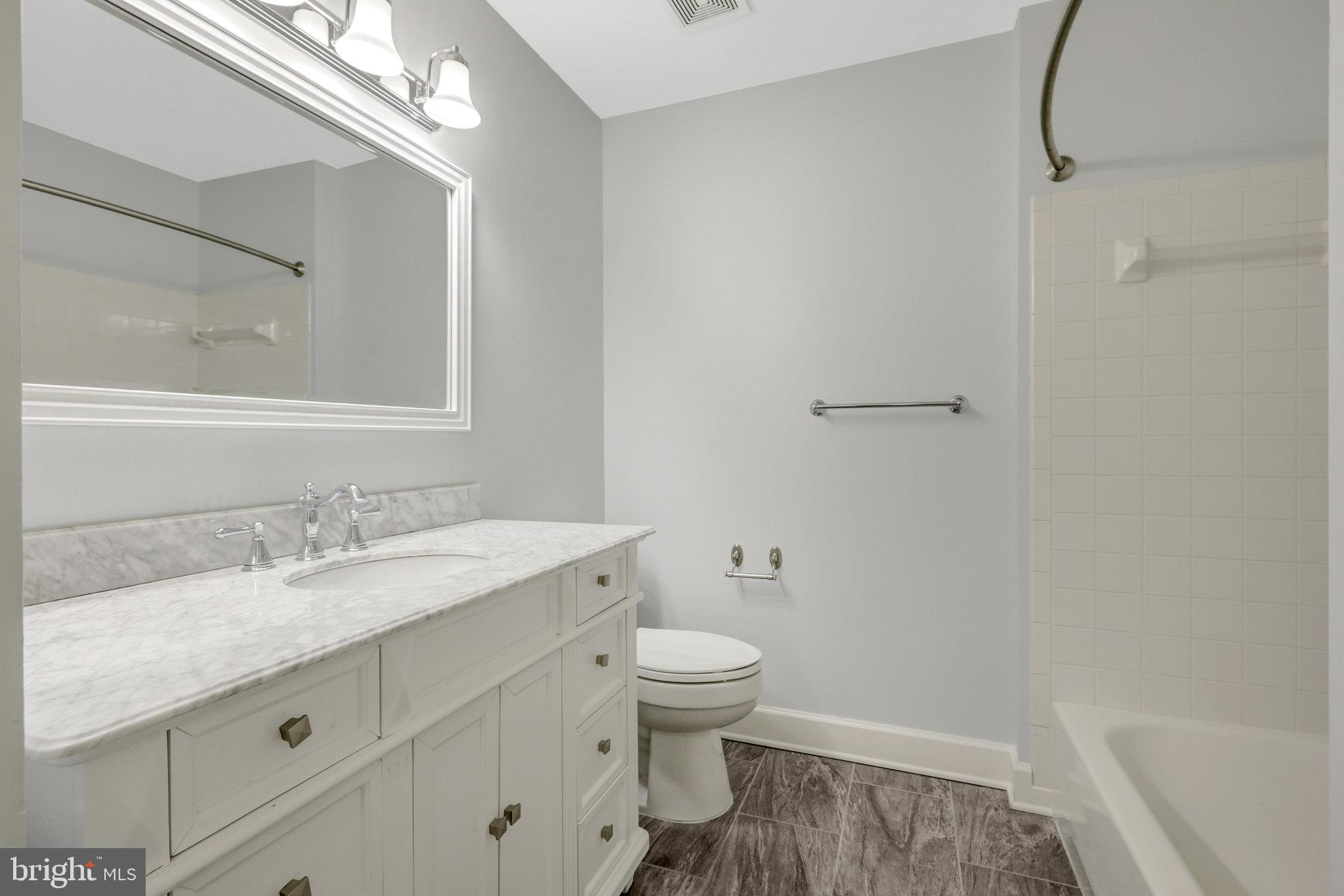 43233 Stillforest Terrace Ashburn, VA 20147 - Photo 19 of 24 a bathroom with a granite countertop sink a toilet and a mirror