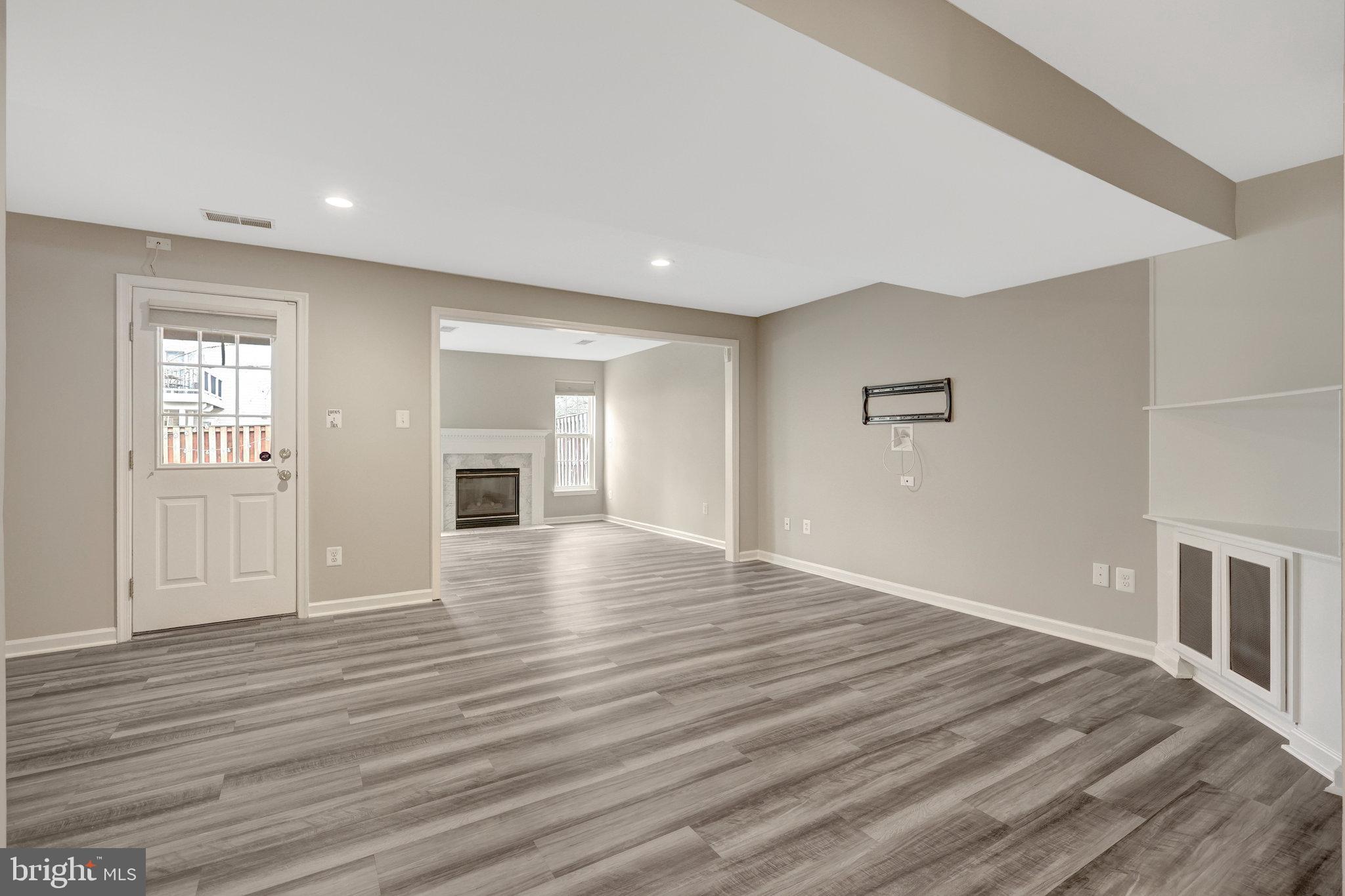 43233 Stillforest Terrace Ashburn, VA 20147 - Photo 20 of 24 a view of empty room with wooden floor and fireplace