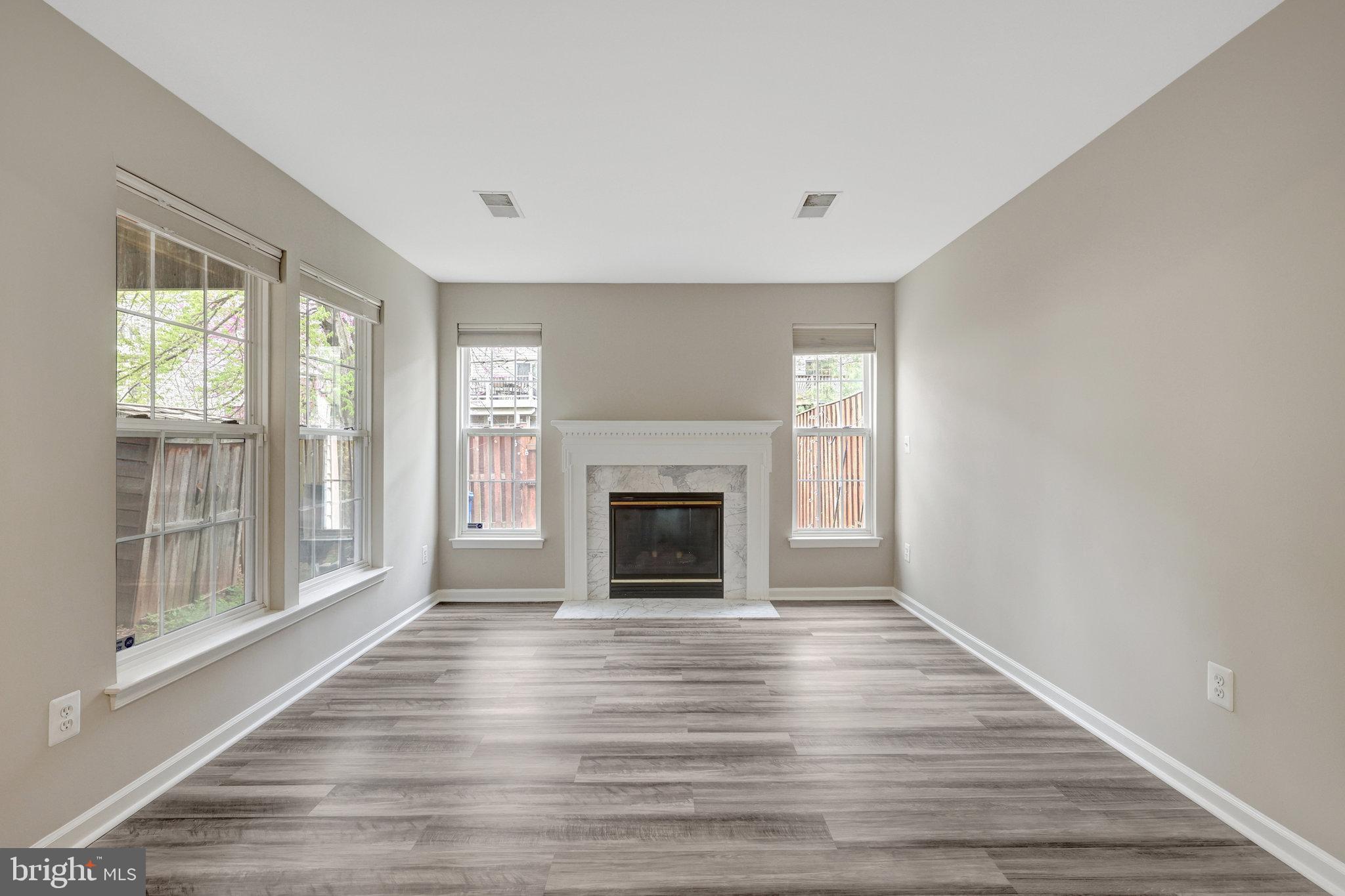 43233 Stillforest Terrace Ashburn, VA 20147 - Photo 21 of 24 a view of an empty room with wooden floor fireplace and a window